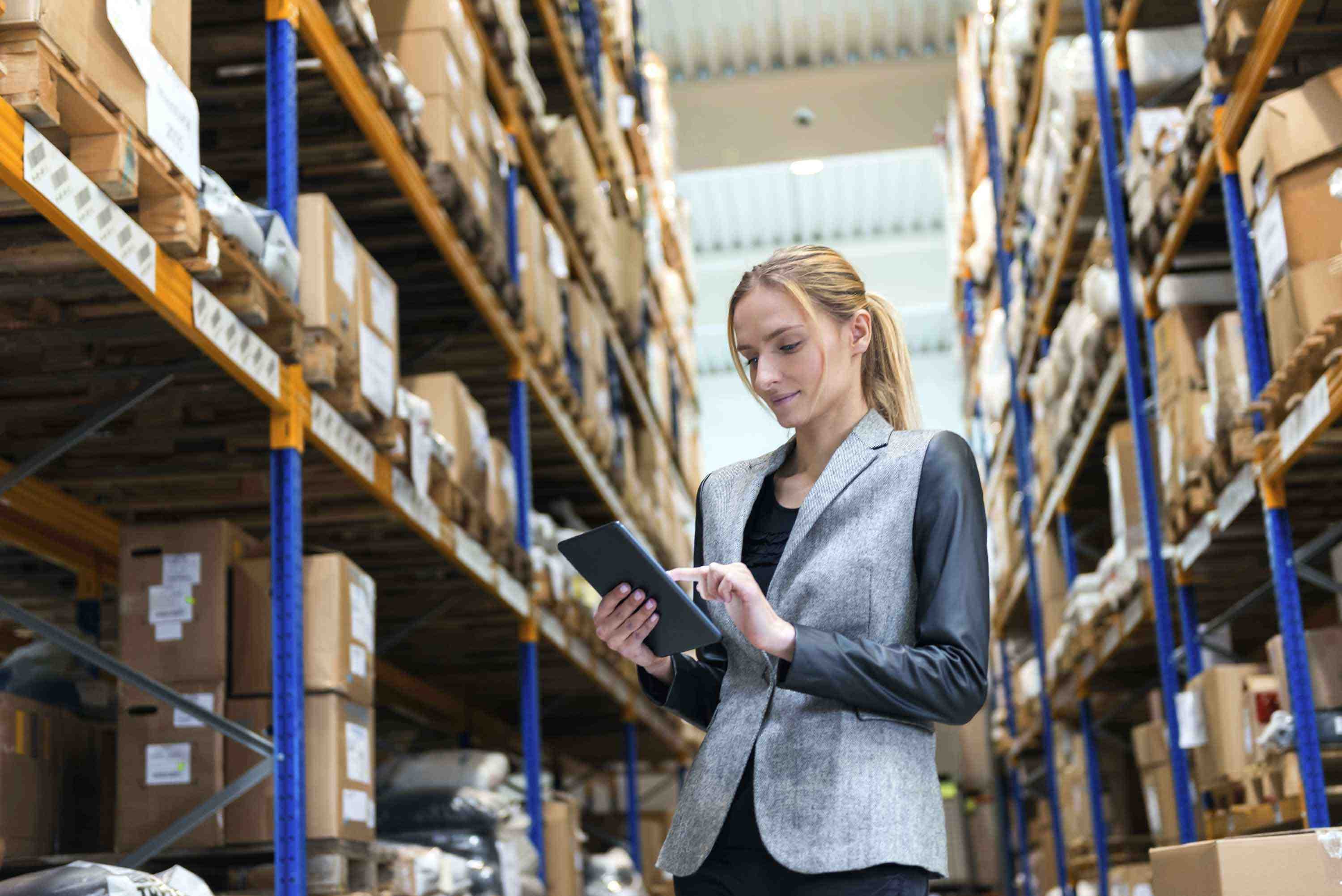 Woman checking tablet on manufacturing floor
