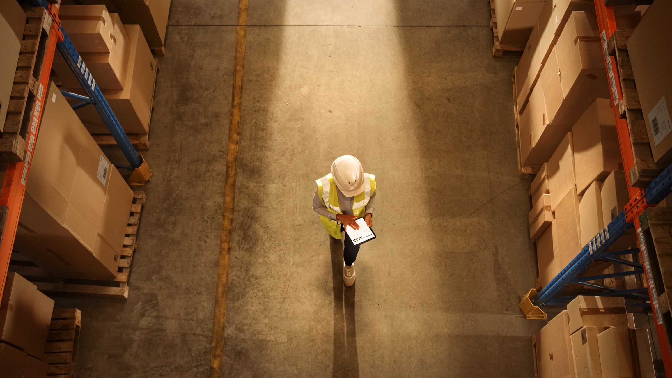 A bird's eye view of a person walking though a warehouse