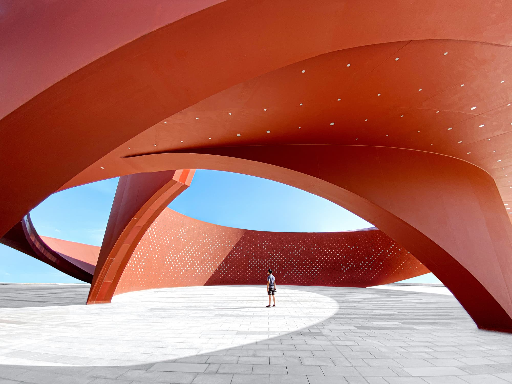 A person looks up through an abstract architectural installment