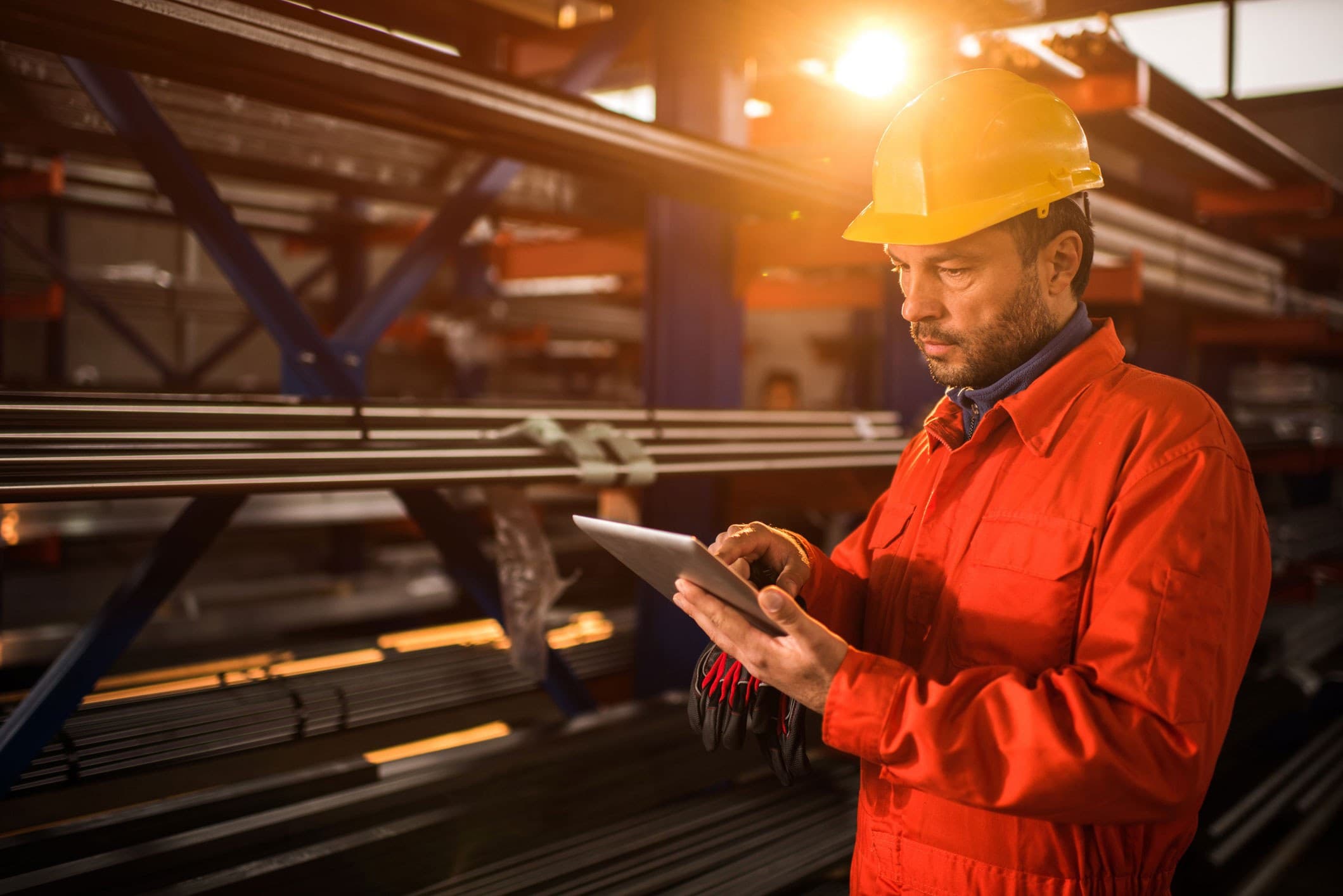 A construction worker references Quickbase on his tablet