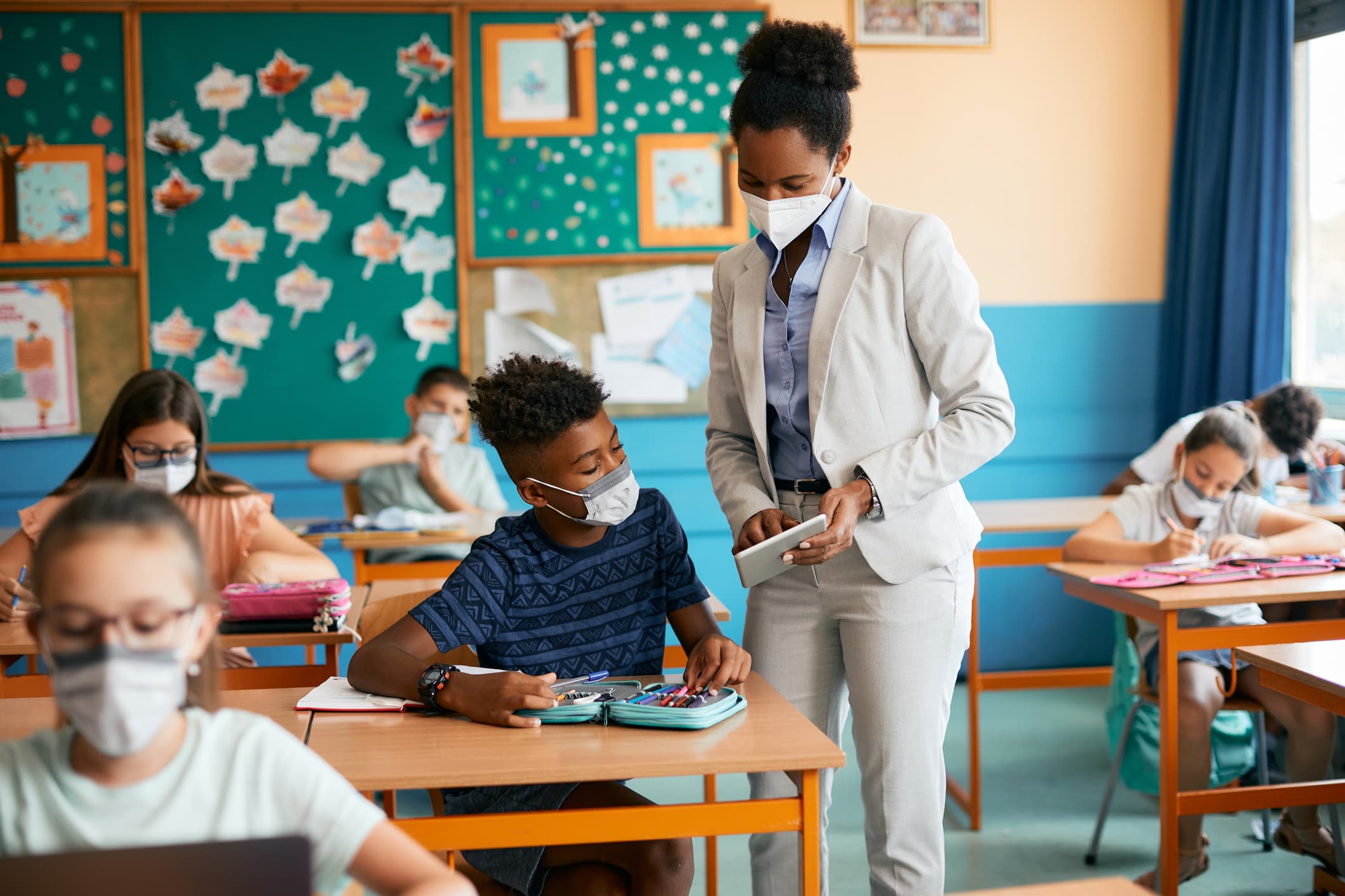 A teacher and student reference a tablet