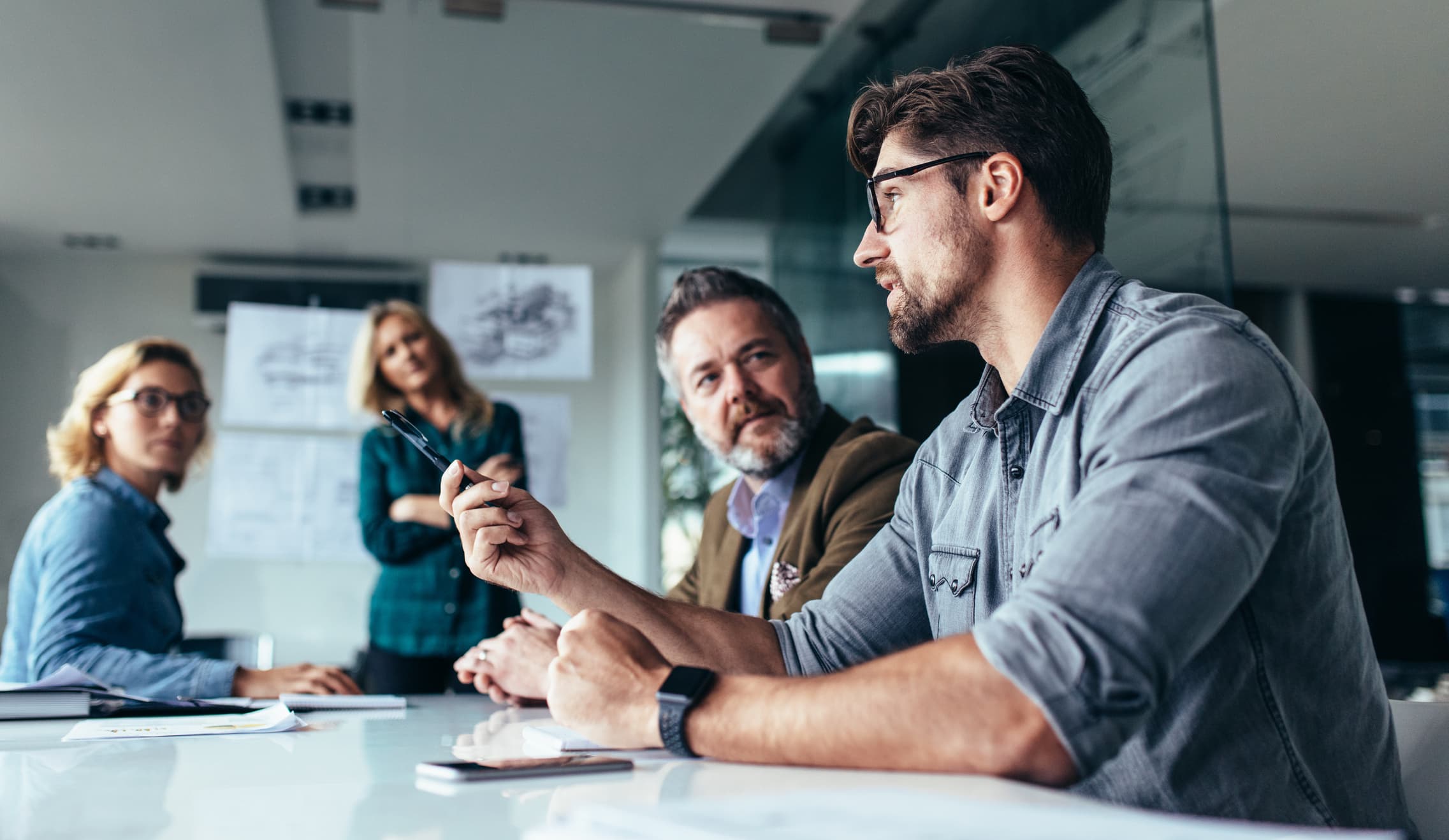 People in office gathered around a table having discussion