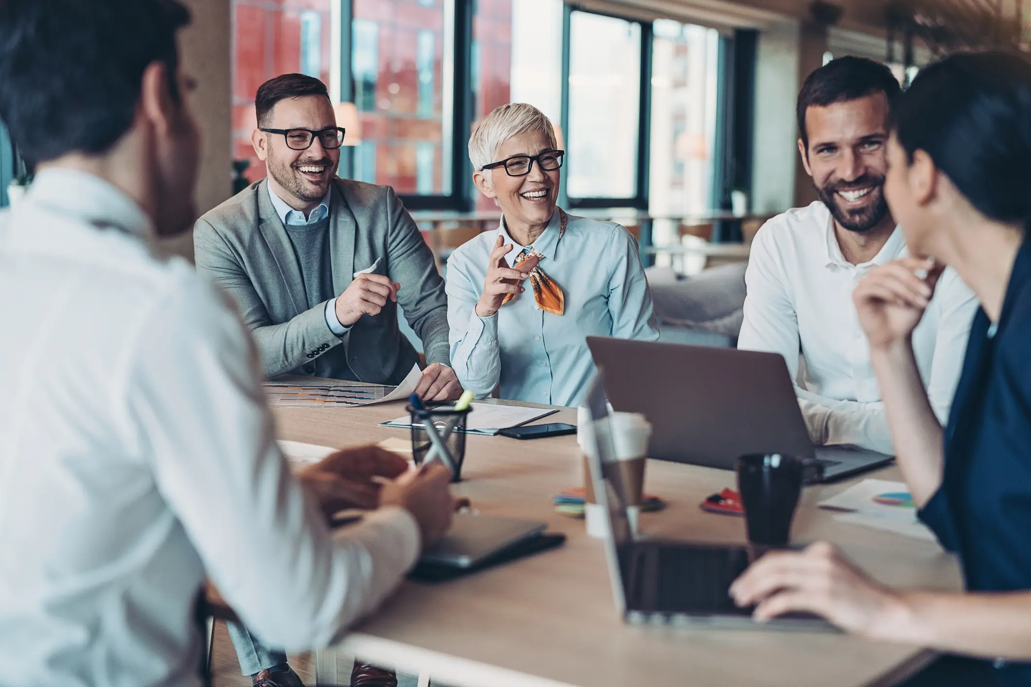 A team of people laughs during a meeting