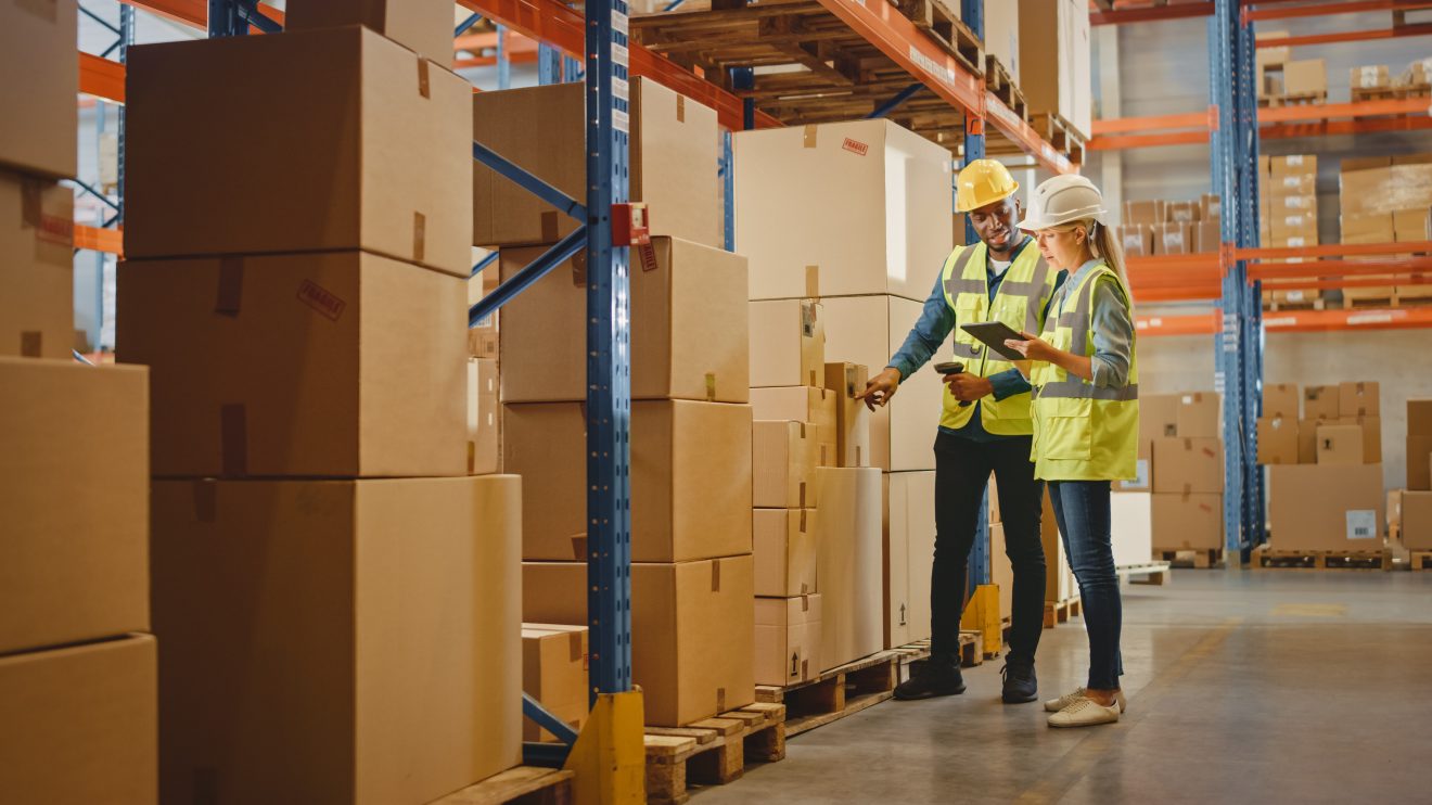 Man and woman scanning boxes in a warehouse